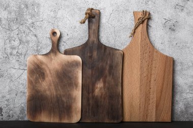 Mutfak tezgahında beton duvara dayalı üç farklı ahşap kereste örneği. Ahşaptan yapılmış ev eşyası ve aksesuar üretimi