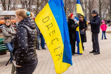 ODESSA, UKRAINE - 20 FEB 2022: Unity march in Odessa against Russian invasion. Ukrainian flag with sign 