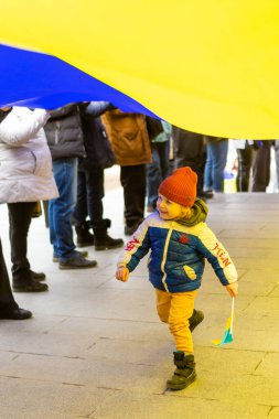 ODESSA, UKRAINE - 20 Şubat 2022: Rus işgaline karşı Odessa 'da birlik yürüyüşü. Ukrayna bayrağıyla gülümseyen küçük çocuk..