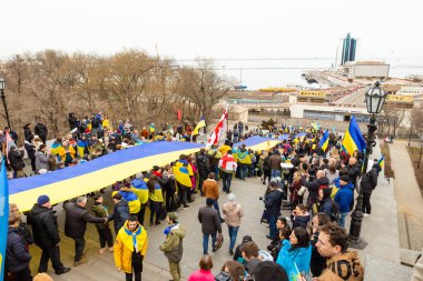 ODESSA, UKRAINE - 20 FEB 2022: Unity march in Odessa against Russian invasion. People with blue and yellow flag on Potemkn stairs. clipart