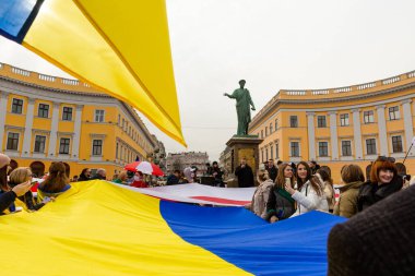 ODESSA, UKRAINE - 20 Şubat 2022: Rus işgaline karşı Odessa 'da birlik yürüyüşü. Potemkn merdivenlerinde mavi ve sarı bayraklı insanlar. Duk Heykeli