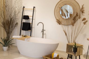 Küvetli ve musluklu modern banyo. Sabun ve temiz havluların panoramik görüntüsü, bitki süslemeleri, ayna, ahşap zemin. Lüks banyo, iç tasarım konsepti..