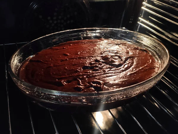 Ev yapımı kek mutfakta elektrikli fırında pişirmek için özel olarak hazırlanır ve pişirilir. Fırın kapısı açık çiğ kekin manzarası.