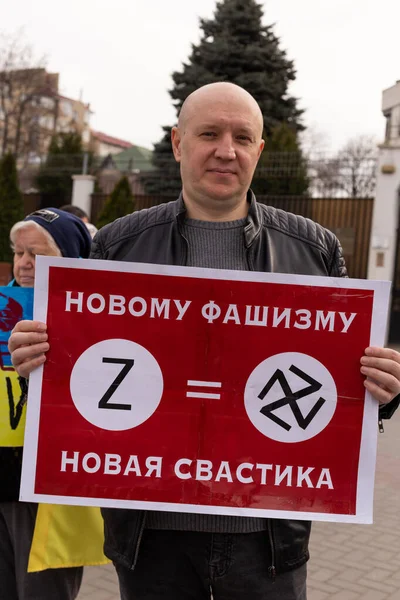 KISHINEV, MOLDOVA - 29 Mart 2022: Ukrayna 'yı desteklemek için halk toplantısı. Rusya Federasyonu büyükelçiliğinin yanında Ukrayna bayrakları ve posterleri olan insanlar. Faşizmin sembolü..