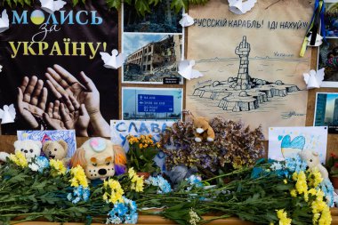 CHISINAU, MOLDOVA - CIRCA MAYIS 2022: Moldova, Chisinau 'daki Ukrayna elçiliği yakınlarındaki hafıza duvarı. Rus-Ukrayna savaşı kavramı, yıkılmış Ukrayna şehirlerinin resimleri, ölmüş insanların anısına çiçekler..