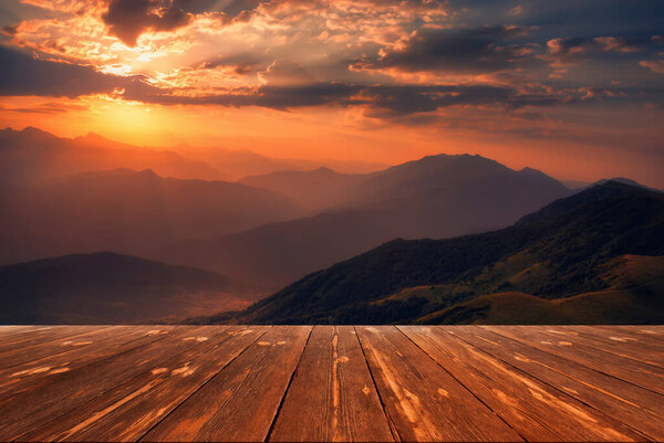 Sunrise over caucasus mountain range with empty wooden table. Natural template landscape.
