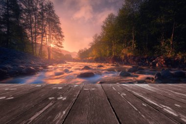 Boş ahşap batten köprüsü olan hızlı akan dağ nehri üzerinde büyülü bir gün doğumu. Doğal şablon manzarası.