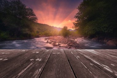 Boş ahşap batten köprüsü olan hızlı akan dağ nehri üzerinde büyülü bir gün doğumu. Doğal şablon manzarası.