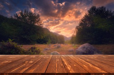 Yazın güzel arka planı, dağların üzerinde gün doğumu ve doğada boş ahşap masa. Doğal şablon manzarası.