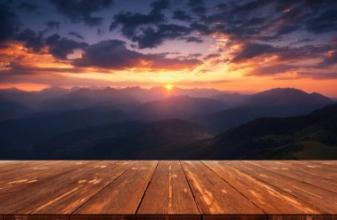 Yazın güzel arka planı, dağların üzerinde gün doğumu ve doğada boş ahşap masa. Doğal şablon manzarası.