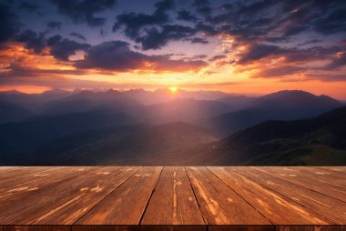 Yazın güzel arka planı, dağların üzerinde gün doğumu ve doğada boş ahşap masa. Doğal şablon manzarası.