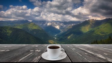 Kahve fincanı ahşap masada ve güzel doğa manzaralı..