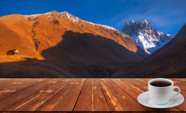 Kahve fincanı ahşap masada ve güzel doğa manzaralı..