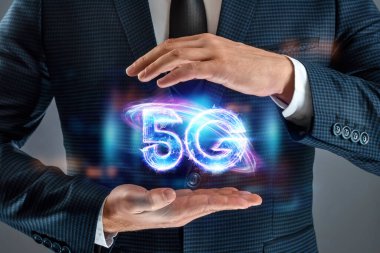 İş adamı 5G hologramı, yaratıcı bir geçmişi var. 5G ağ konsepti, yüksek hızlı mobil internet, yeni nesil ağlar. Karışık ortam