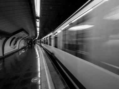 İstasyondan ayrılan metro treninin siyah beyaz fotoğrafı. Ulaşım kavramı.