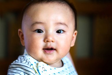 Güzel bebeğin yüzü kameraya bakar ve siyah bir arkaplanda boşluğu kopyalar..