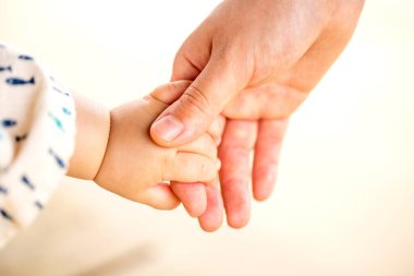 Aile sahnesi, yakın çekim ebeveyn ve bebek beyaz arka planda el ele tutuşuyorlar..