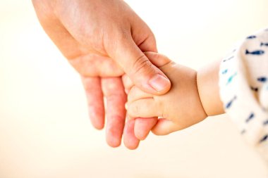 Aile sahnesi, yakın çekim ebeveyn ve bebek beyaz arka planda el ele tutuşuyorlar..