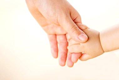 Aile sahnesi, yakın çekim ebeveyn ve bebek beyaz arka planda el ele tutuşuyorlar..