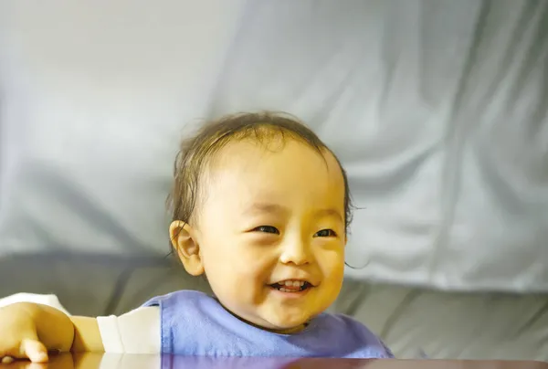 Ein Kleiner Junge Des Lächelns Drinnen Und Holztisch Und Kopierraum — Stockfoto
