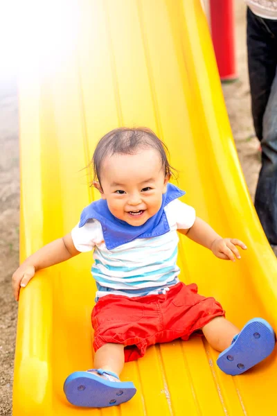 Criança Brinca Com Slide Amarelo Ele Está Todo Sorridente Num — Fotografia de Stock