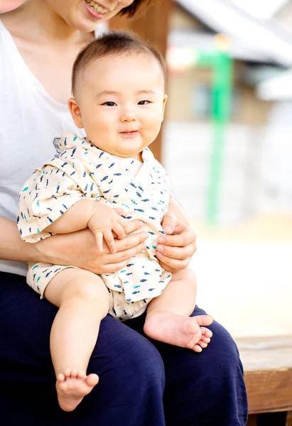 Eine Schöne Junge Mutter Hält Ein Baby Auf Den Knien — Stockfoto
