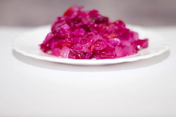 Красный салат на белой тарелке . — стоковое фото
