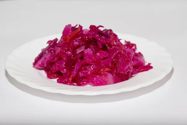 Червоний салат на білій тарілці . — стокове фото