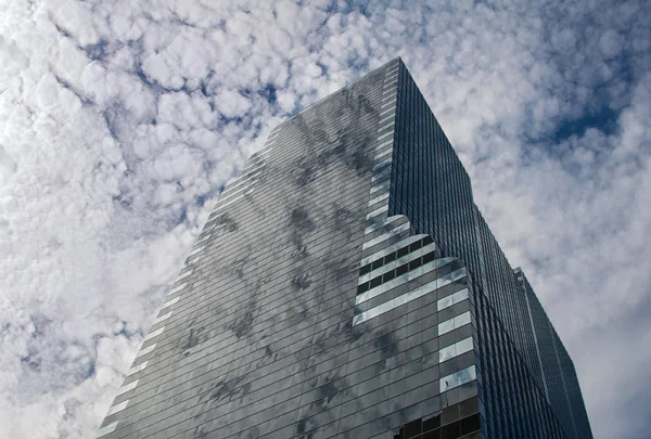 Reflexão de nuvens em um arranha-céu de vidro — Fotografia de Stock