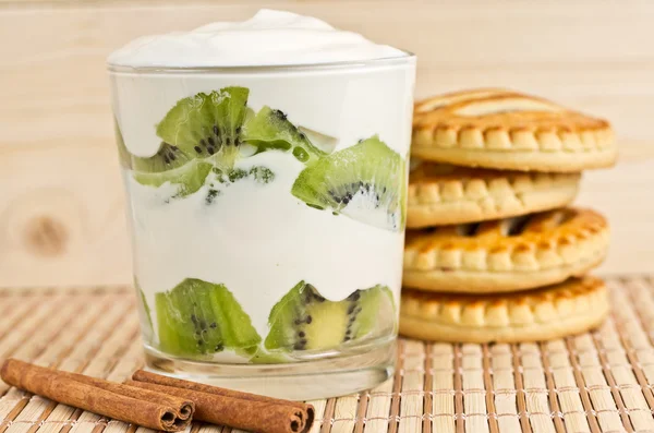 Kiwi slices in a glass with cream — Stock Photo, Image