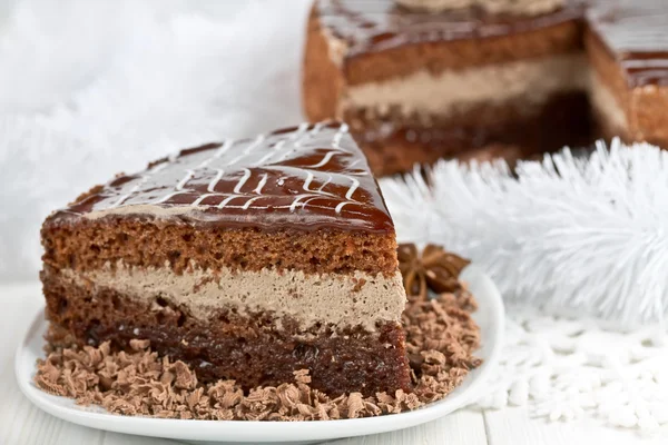 Piece of chocolate cake and tinsel snowflake — Stock Photo, Image