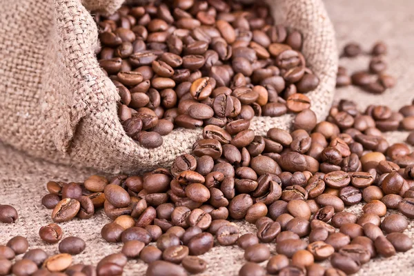 Chicchi di caffè fuoriusciti dal sacchetto di iuta — Foto Stock