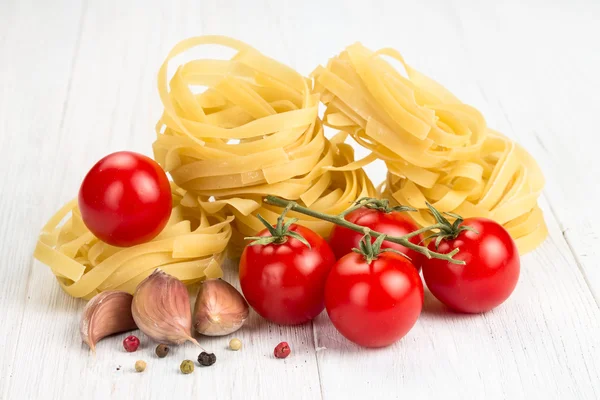 Nido de fideos de huevo con tomates y ajo —  Fotos de Stock