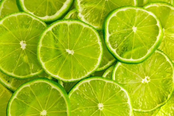 Grön bakgrund med lime skivor — Stockfoto