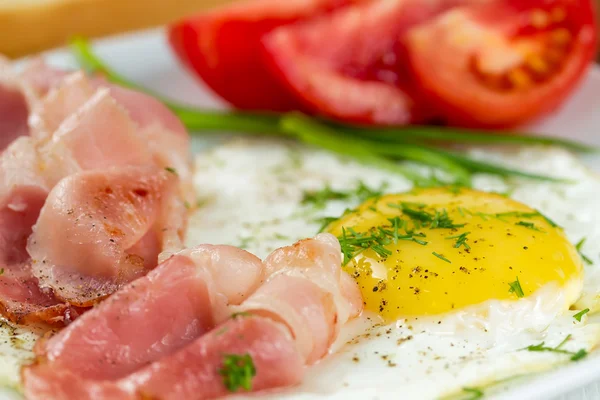 Fried eggs with ham and tomatoes — Stock Photo, Image