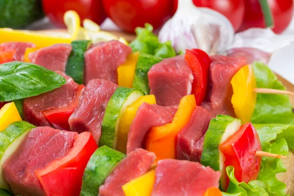 Carne em espetos em folhas de salada — Fotografia de Stock