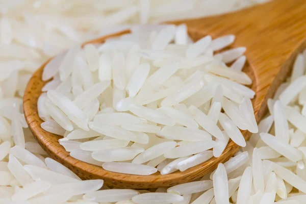 Arroz em uma colher de madeira — Fotografia de Stock