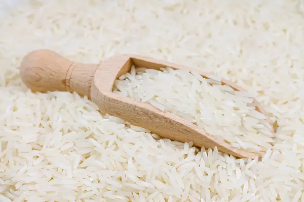 Arroz em uma colher de madeira — Fotografia de Stock