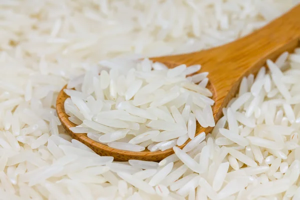 Arroz de grão longo em uma colher de madeira — Fotografia de Stock