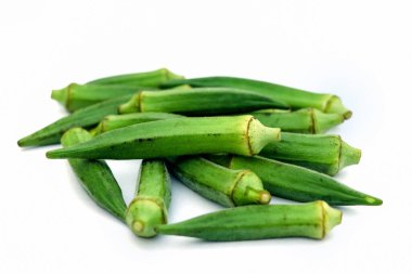 Beyaz arkaplanda çiğ bamya ya ya da kadın parmağı var.