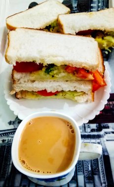 Ekmekli sandviç ve masada bir fincan çay.