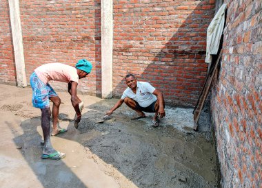 Lucknow, Hindistan, Ekim 2021: Hintli işçiler yerde elle kürek kullanıyorlar
