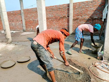 Lucknow, Hindistan, Ekim 2021: Hintli işçiler yerde elle kürek kullanıyorlar