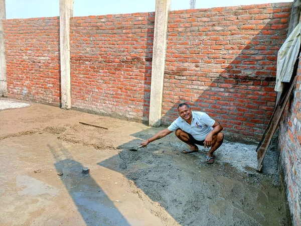 Lucknow, Hindistan, Ekim 2021: Hintli işçiler yerde elle kürek kullanıyorlar