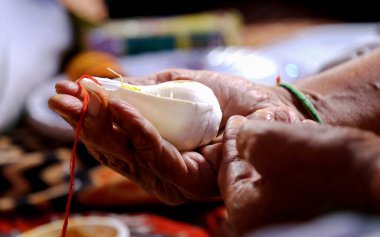 Tapınma sırasında deniz kabuğu kabuğunu (shankh) tutmak, tapınmak ve virüsü kaldırmak için sankhnaad