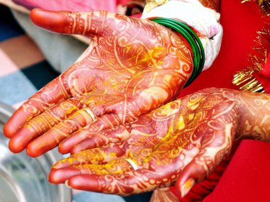 An Indian bride showing her hand's mehndi tattoos design