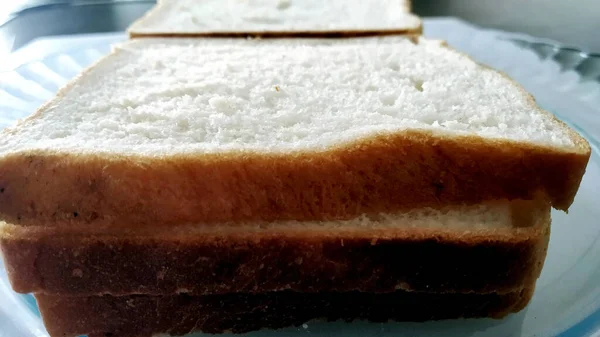 Ein Paar Scheiben Brot Einem Teller Auf Einem Holztisch — Stockfoto