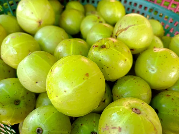 An Indian gooseberry in the basket on a wooden floor