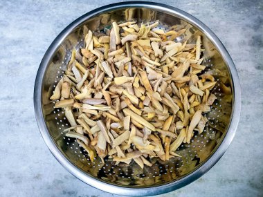 Zencefil parçalarını turşu için süzgeçte kurutuyorum.