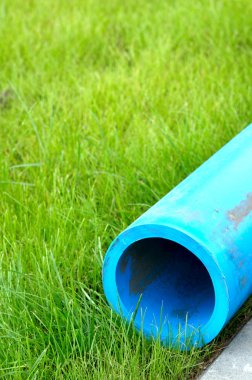 Yeşil çimenlerin üzerinde zararsız polietilen su boruları